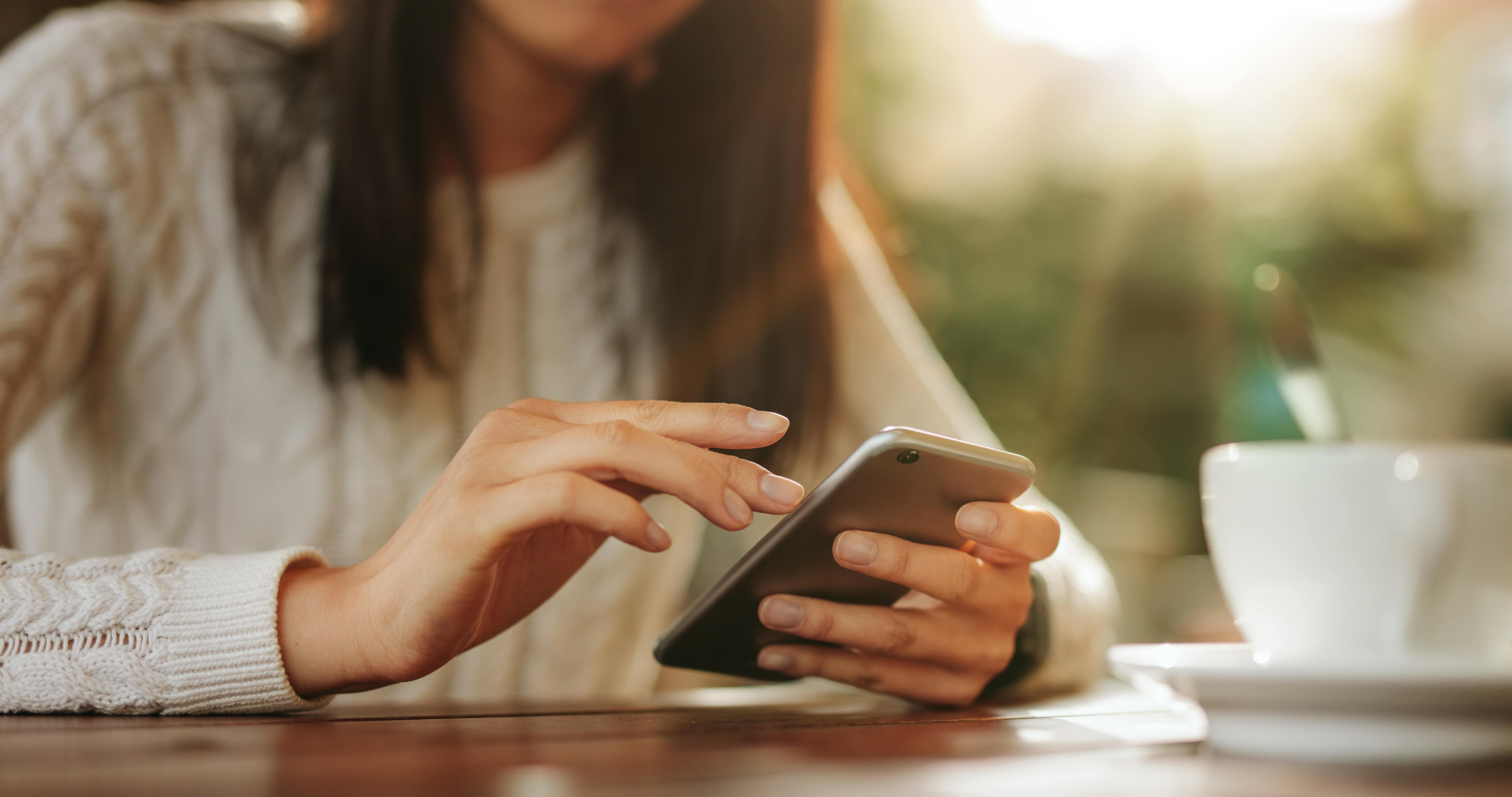 Woman sitting at a table using mobile phone